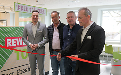 Symbolisches Zerschneiden des roten Bandes bei der Eröffnung des Kiosk
