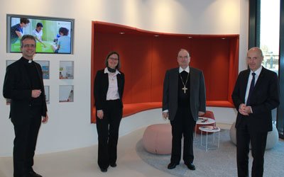 Domkapitular Armin Zürn (links) und Vorstandsvorsitzender Direktor Markus Mayer (rechts) empfangen Sr. Anna Schenk und Bischof Dr. Bertram Meier in der KJF Zentrale. Foto: KJF Augsburg/Angelika Urbach