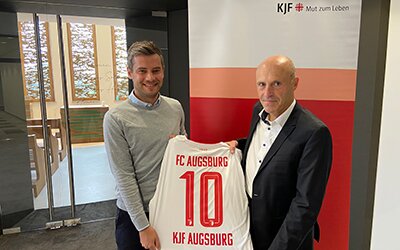 Markus Mayer (rechts), Vorstandsvorsitzender der KJF Augsburg, und Nicolas Pfann, Leiter Sponsoring des FC Augsburg. 