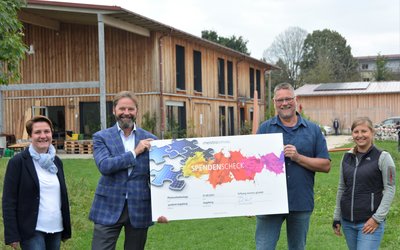 Anett Hantschke-Neumann und Geschäftsführer Mike Frank von der Stiftung meistro gGmbH (links) überreichen den Spendenscheck an den Einrichtungsleiter Frank Helbig und Mitarbeiterin Sheeren Ohnesorge von der youfarm. Foto: KJF Augsburg/Jasmin Mächtlinger